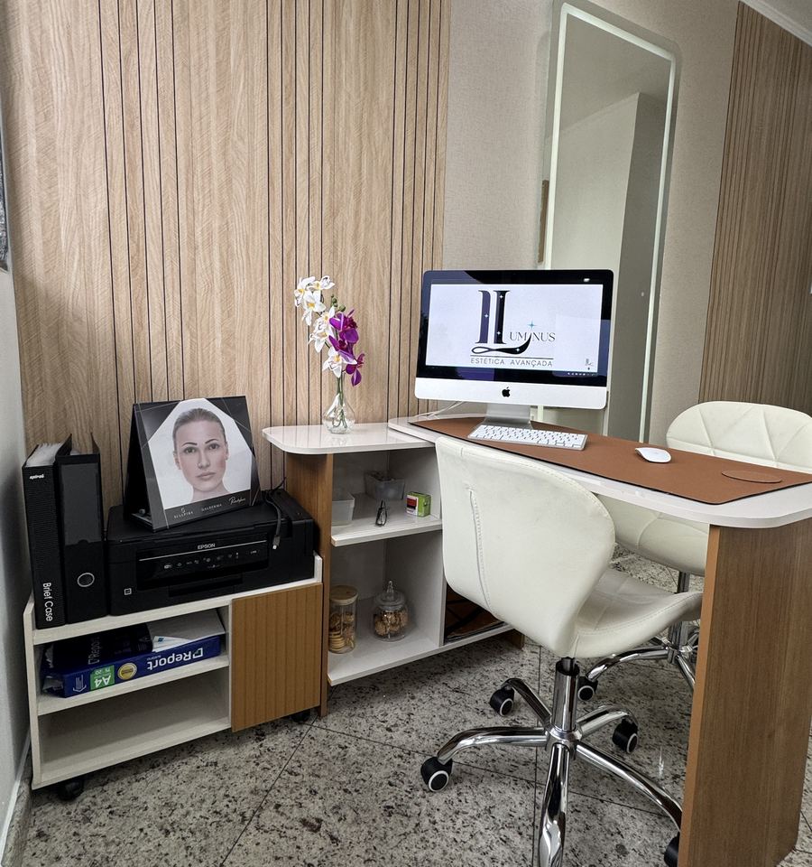 Recepção da Luminus com o logo da clínica na tela do computador